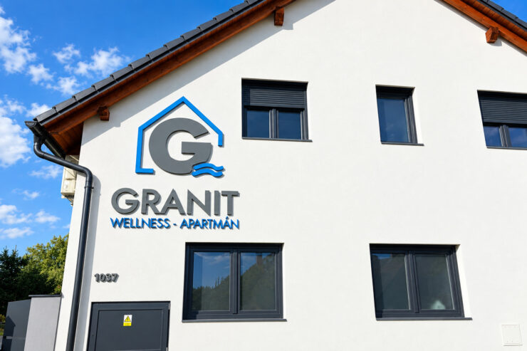 3D logo a nápis Granit Wellness Apartmán na fasádě budovy