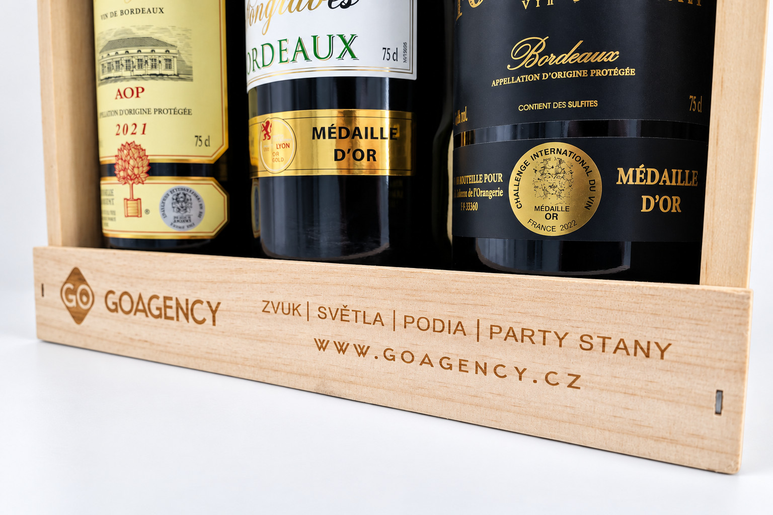 Dřevěná bedna s lahvemi vína a gravírem GO Agency