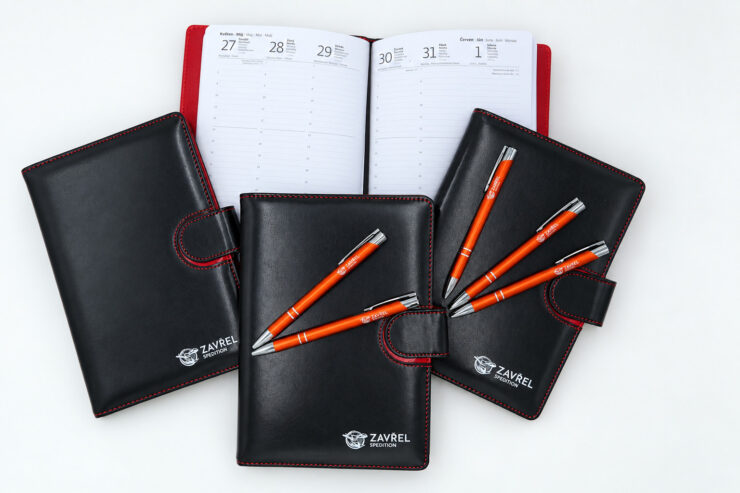 Černé obaly na diáře s potiskem a oranžové tužky
